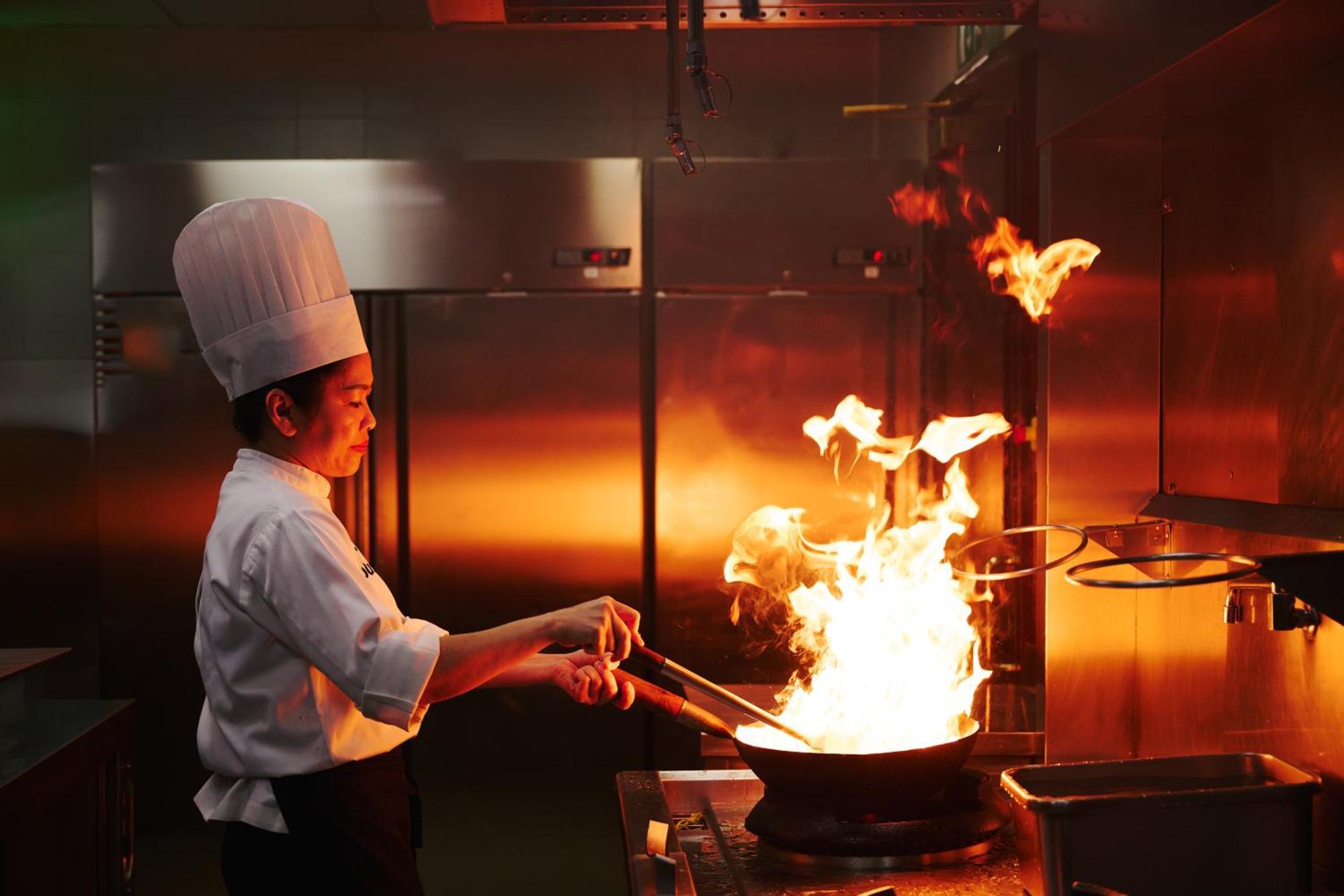โรงแรมดุสิต โดฮา ภายนอก รูปภาพ A chef cooking with a wok